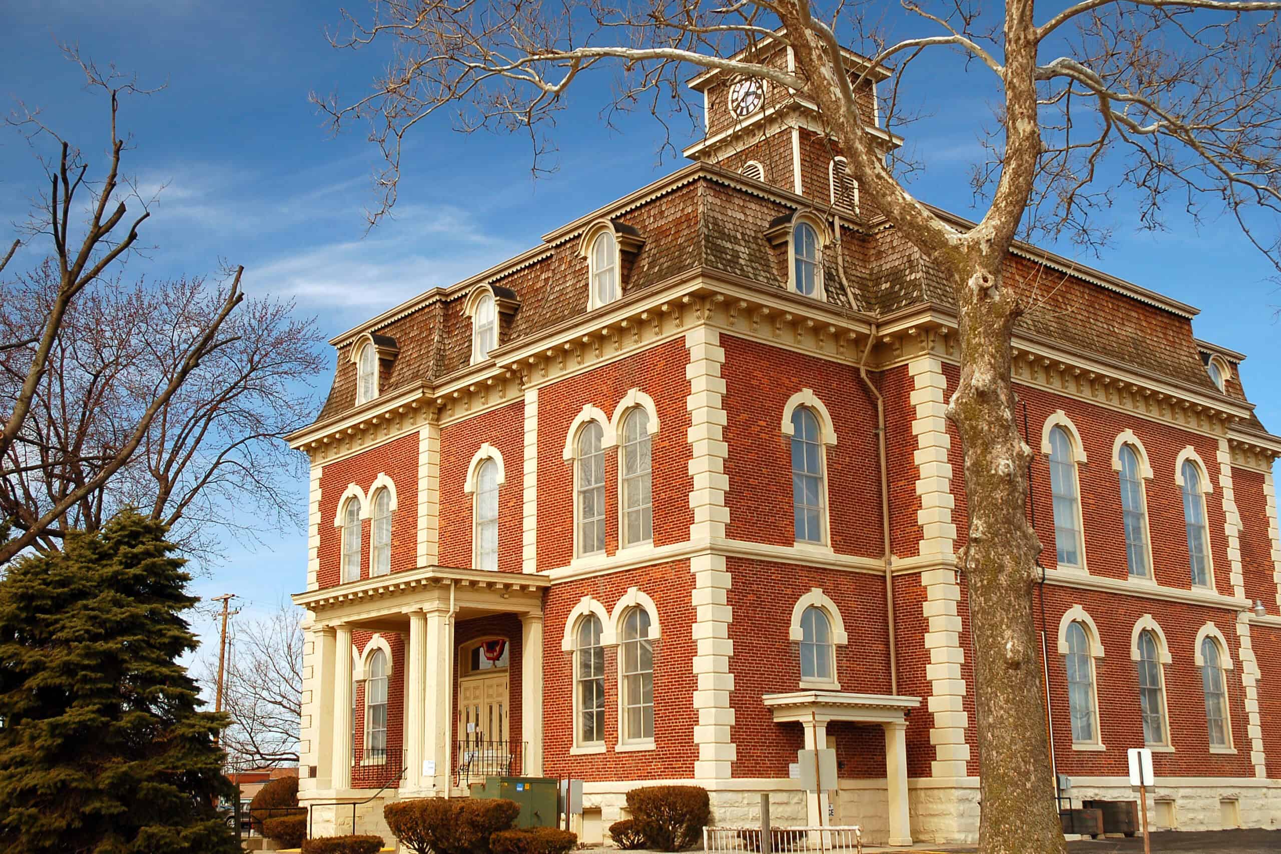 Close up image of a beautify older styled building with red walls and brown and white trims